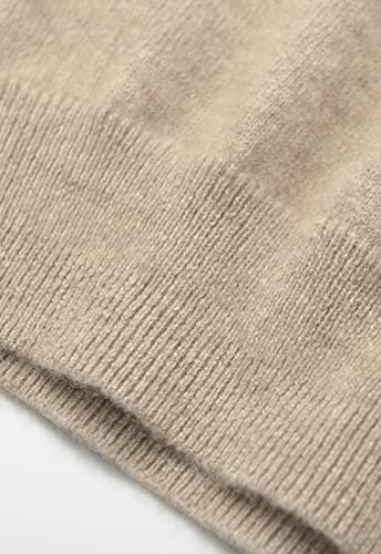 Close-up of beige knit fabric texture.