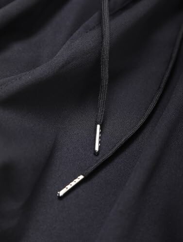 Close-up of black fabric with drawstring ends.