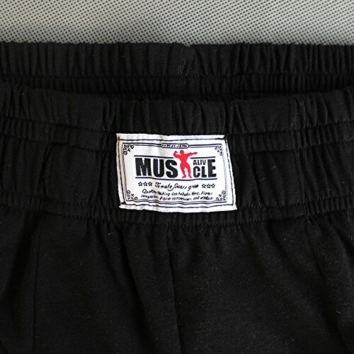 Close-up of black shorts with an elastic waistband and a Muscle Alive label.