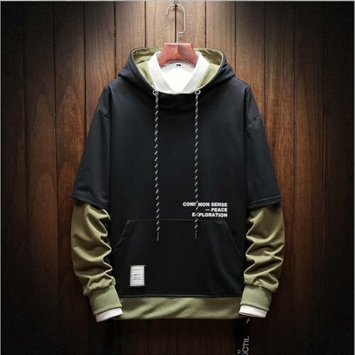 Black and green layered hoodie with text on front.
