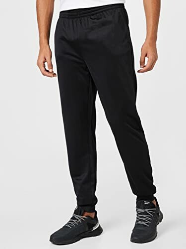 Man wearing black sweatpants and sneakers.