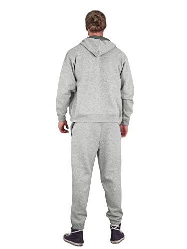 Person wearing gray tracksuit, back view.