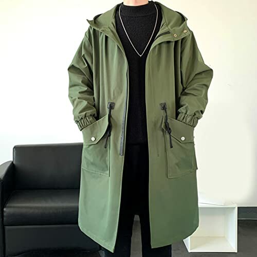 Person wearing a green hooded jacket with black sweater and pants.
