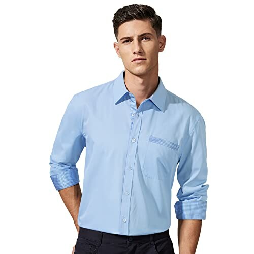Man in a blue button-up shirt with rolled sleeves