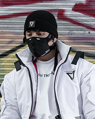 Person in streetwear with black mask and beanie