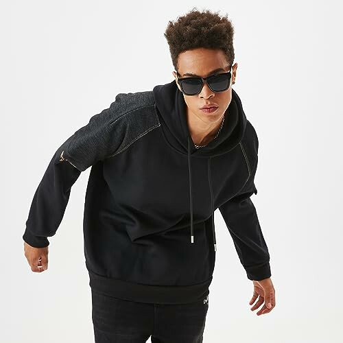 Person wearing a black hoodie and sunglasses.