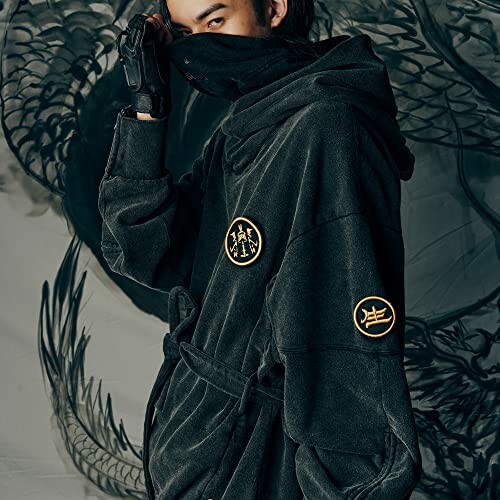 Person wearing a stylish hooded jacket with dragon design in the background.